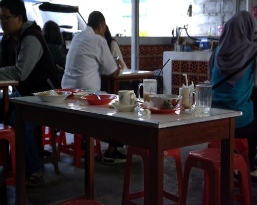 Indonesian family enjoying home cooked meal and fresh water at dining table